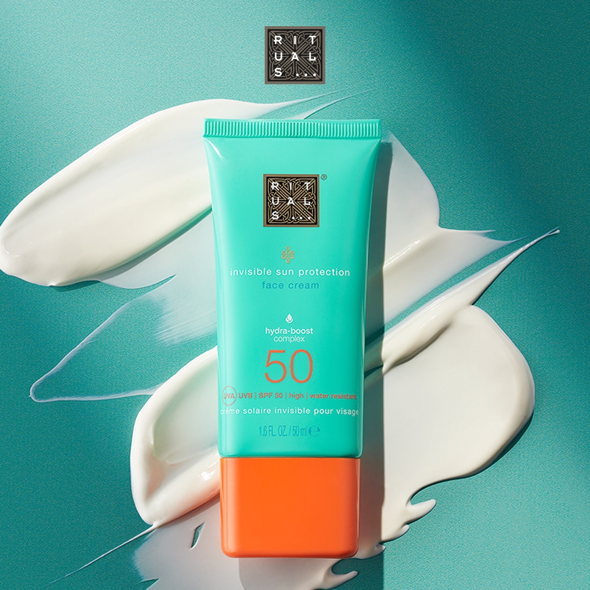 Ecco la crema solare invisibile per il viso di Rituals, con protezione SPF 50 e complesso idratante, presentata in un tubo turchese con dettagli arancioni, circondata da strisce di crema bianca.