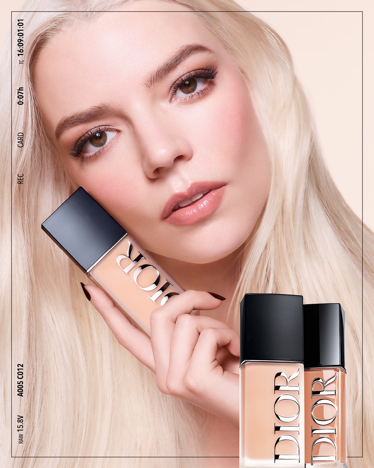 Primo piano di una modella bionda che tiene in mano un flacone di fondotinta Dior color crema, con altri due flaconi in primo piano che mostrano diverse tonalità.