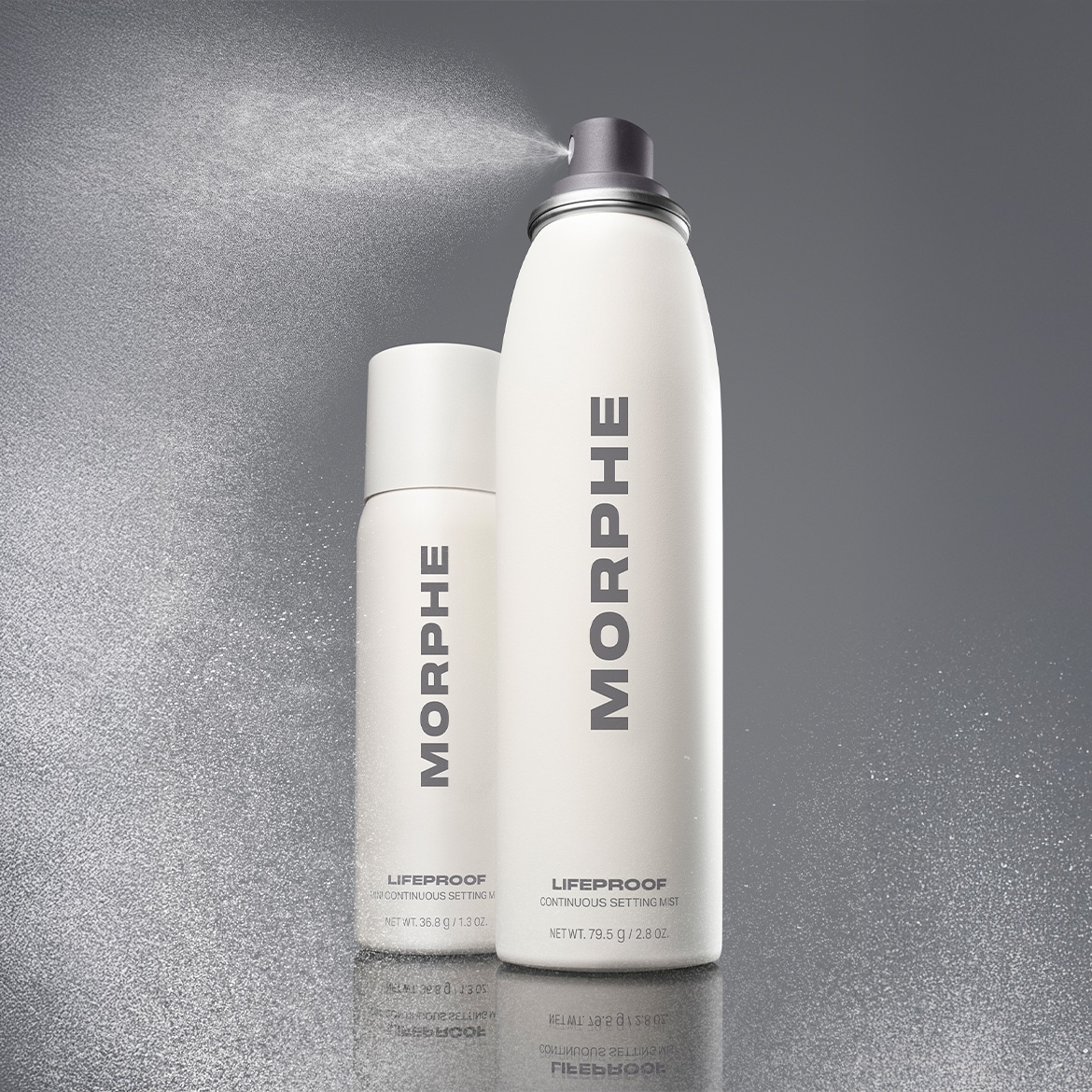 Ecco due flaconi spray bianchi di Morphe LifeProof Continuous Setting Mist, uno più grande dell'altro, su uno sfondo grigio scintillante.