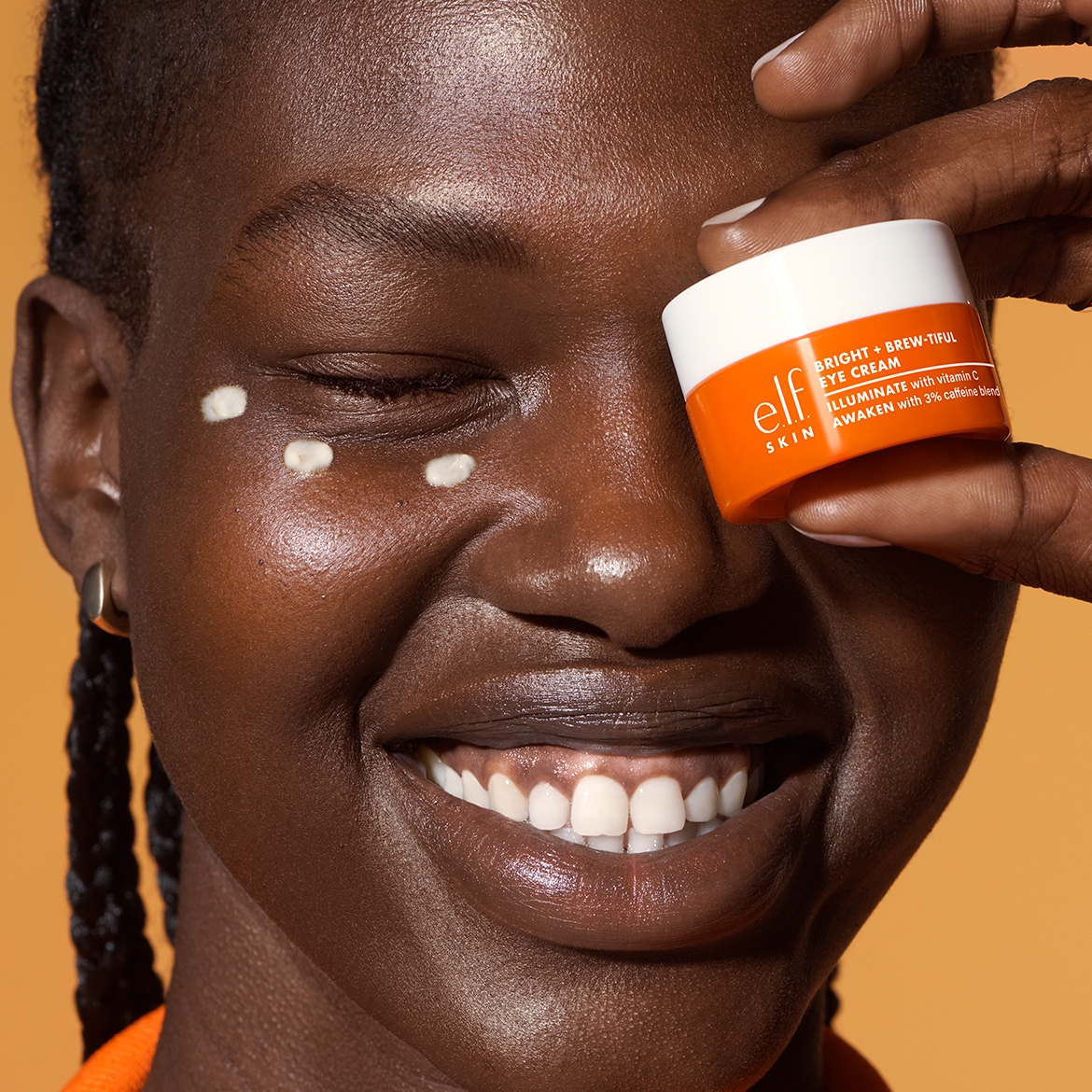 Ecco la crema occhi Bright + Brew-tiful di e.l.f. SKIN, in una confezione arancione e bianca, progettata per illuminare e risvegliare la pelle con vitamina C e una miscela di caffeina al 3%.