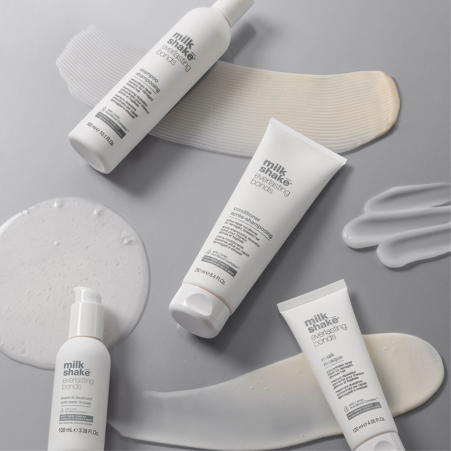 Una gamma di prodotti Milk Shake Everlasting Bonds su sfondo grigio, tra cui shampoo, balsamo, maschera e trattamento leave-in, ideali per riparare i capelli danneggiati e stressati.