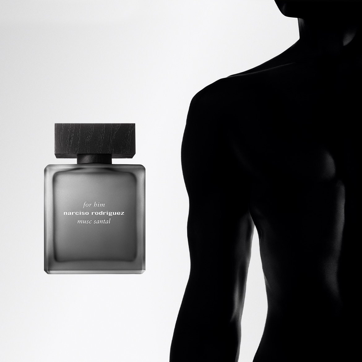 L'immagine mostra una bottiglia di profumo Narciso Rodriguez for him musc santal grigia opaca con tappo in legno scuro, accanto alla silhouette scura di un uomo.