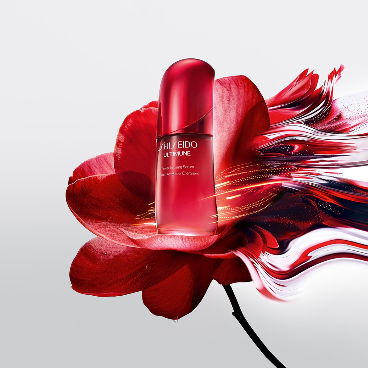 Siero attivatore energetico Shiseido Ultimune in flacone rosso traslucido, adagiato su un fiore rosso stilizzato con accenti luminosi dorati.
