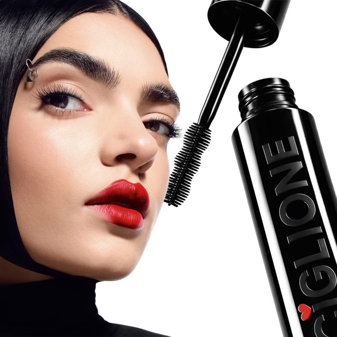 Primo piano di una donna con labbra rosse e mascara nero, accanto al flacone del mascara nero con la scritta Ciglione.