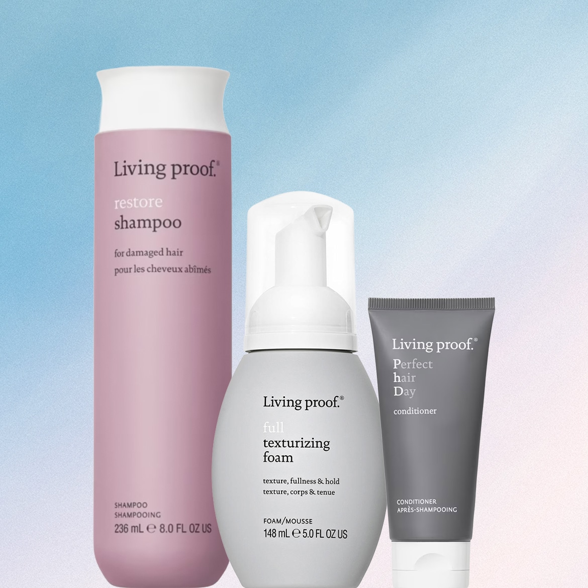 Living Proof Restore Shampoo, Full Texturizing Foam e Perfect Hair Day Conditioner, un set completo per la cura dei capelli, sono presentati su uno sfondo sfumato di blu e bianco.