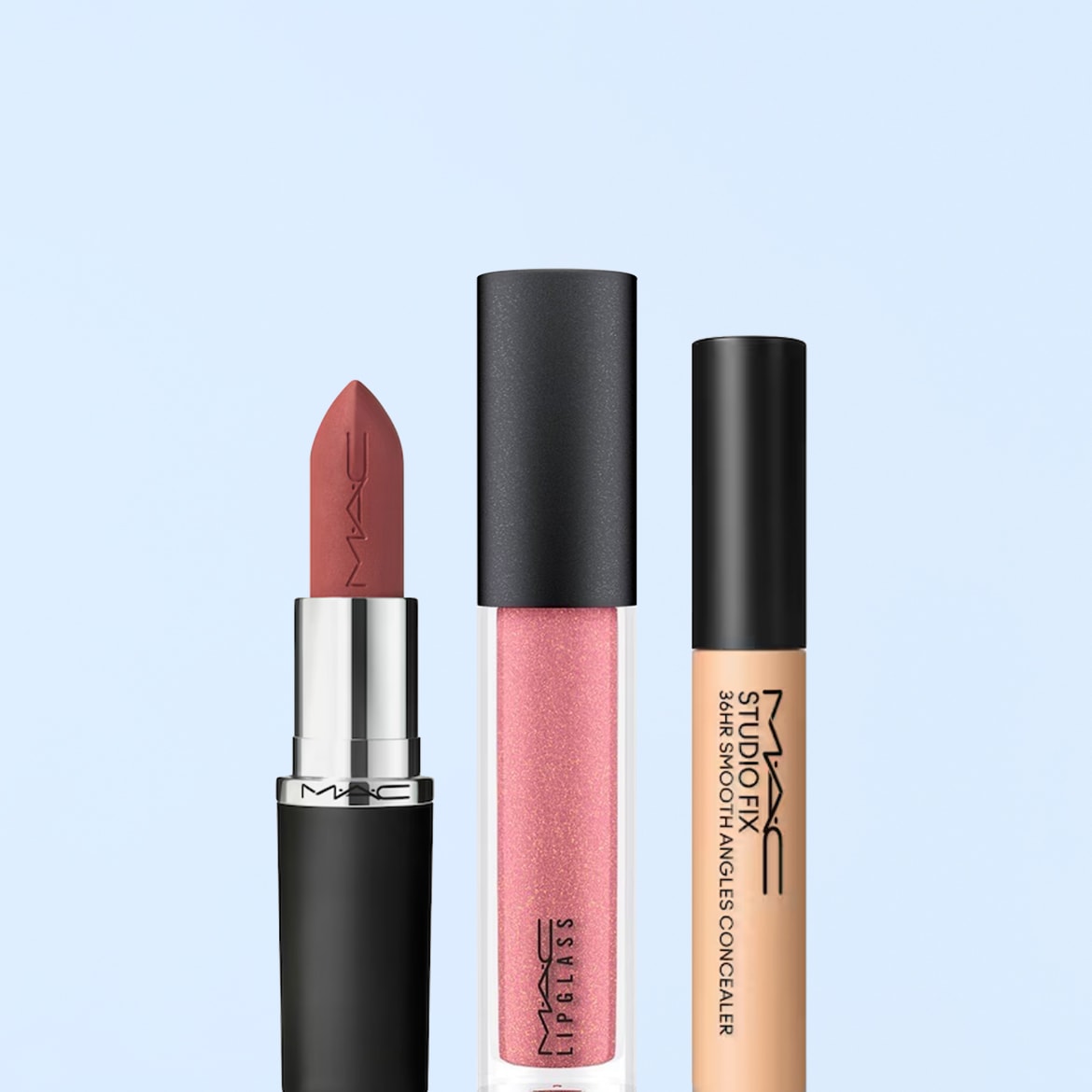 Ecco un rossetto color terracotta con confezione nera opaca, un lipgloss rosa scintillante in un tubetto trasparente e un correttore beige chiaro Studio Fix per una finitura impeccabile.