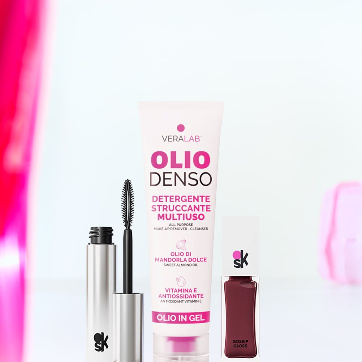 Primo piano di mascara nero e argento, detergente struccante multiuso Verlab Olio Denso e lucidalabbra Gossip Gloss bordeaux.