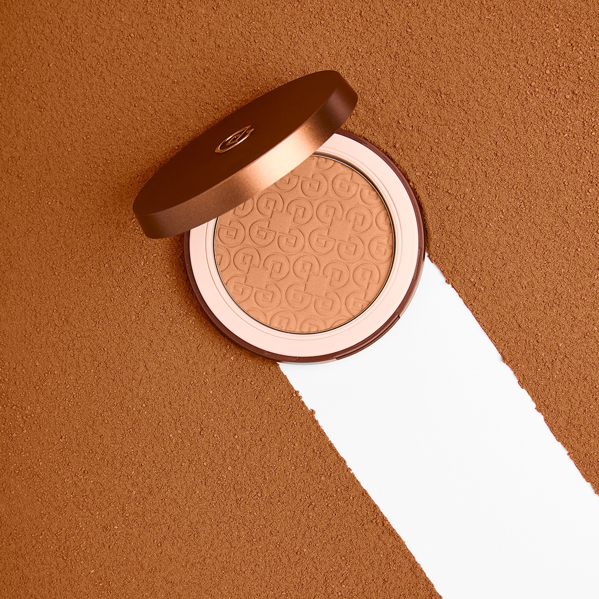 La cipria abbronzante compatta color bronzo chiaro è presentata in un elegante packaging rotondo marrone con il logo in rilievo, ideale per un look estivo impeccabile.