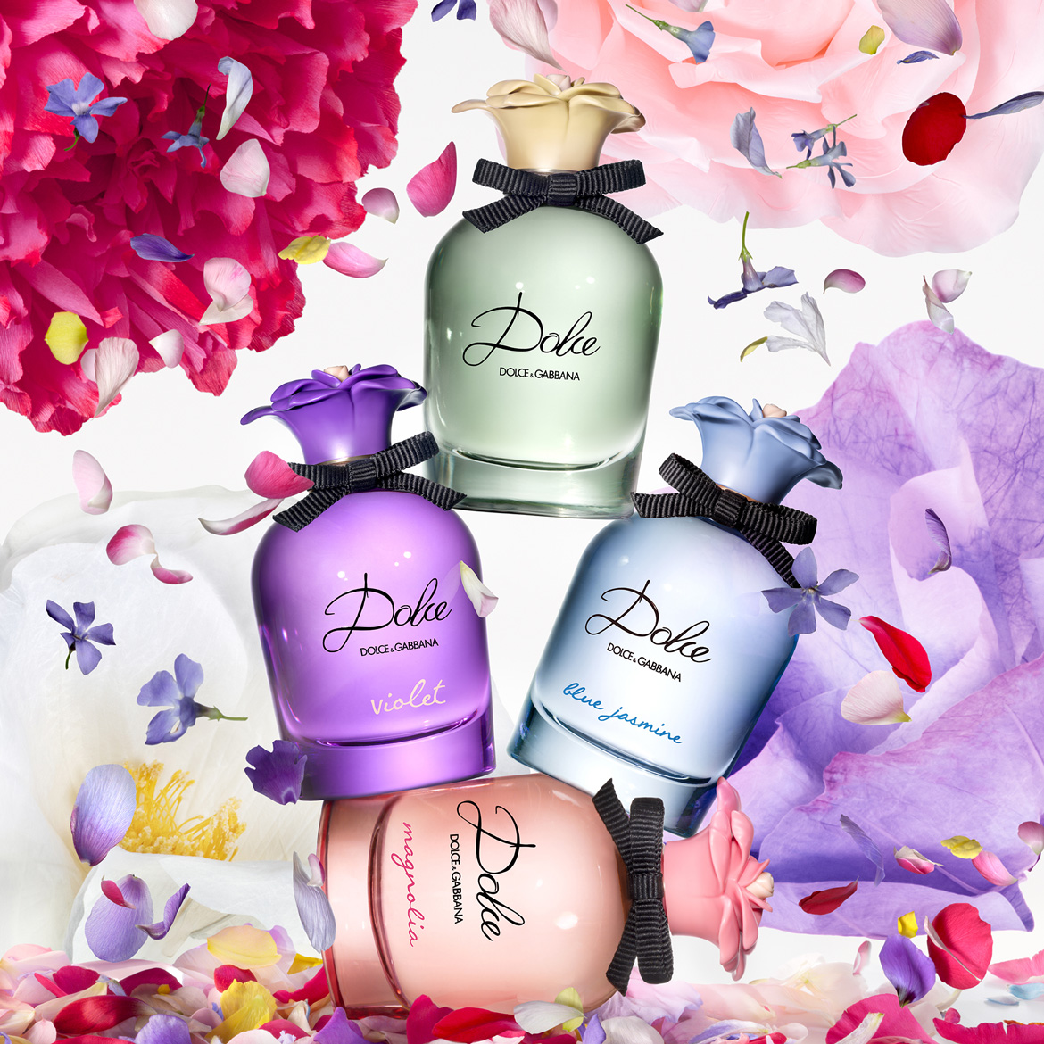 Scopri la collezione Dolce di Dolce&Gabbana: Magnolia, Violet, Blue Jasmine e il classico profumo verde, ognuno con un fiocco nero e petali colorati che fluttuano intorno.