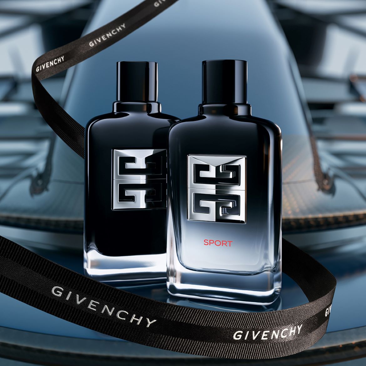 Ecco due flaconi di profumo Givenchy nero lucido, uno con la scritta 'SPORT' in rosso, avvolti da un nastro nero firmato Givenchy.