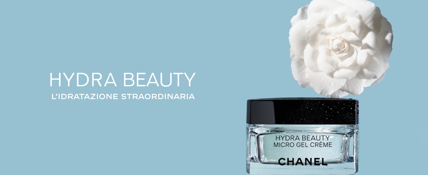 Ecco Hydra Beauty di Chanel, crema in gel micro idratante, presentata in un barattolo trasparente con tappo nero, accanto a un fiore bianco su sfondo azzurro.