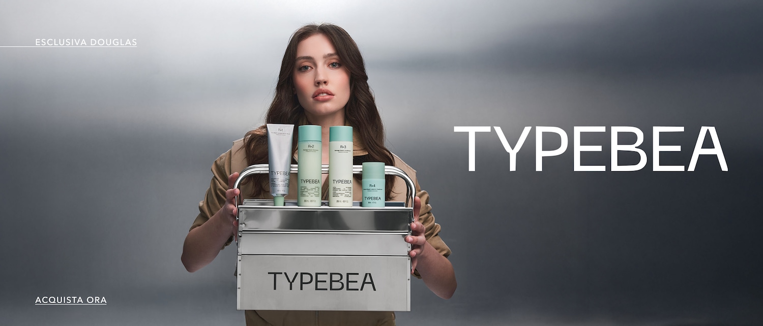 Una donna tiene una scatola di metallo con i prodotti Typebea, tra cui maschera, shampoo, balsamo e trattamento, disponibili in esclusiva da Douglas. Acquista ora!