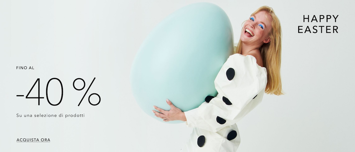 A woman with blonde hair and blue eyeshadow smiles, holding a large, light blue Easter egg, with 'Happy Easter' and '-40% off' visible, inviting you to shop now.
