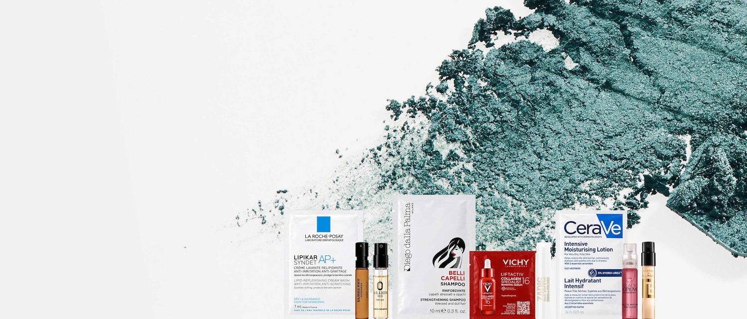Una selezione di prodotti di bellezza, tra cui lozioni idratanti, shampoo rinforzante e sieri, è esposta su uno sfondo bianco con spruzzi di polvere verde acqua.