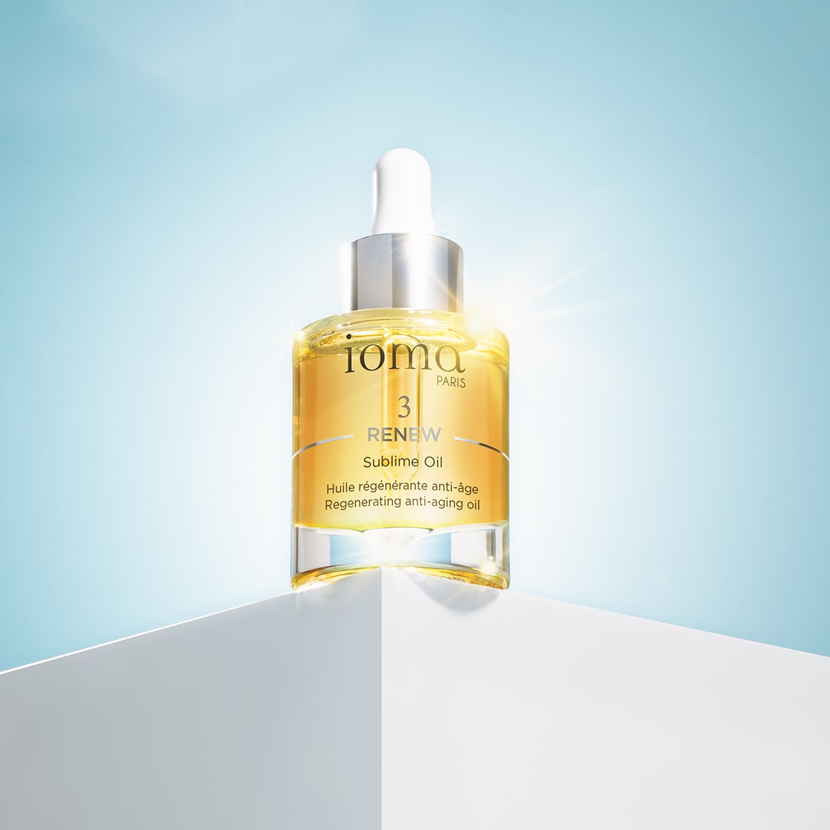 Olio sublime rigenerante anti-età Ioma Paris, confezionato in un flacone trasparente con contagocce bianco e tappo argentato, per una pelle visibilmente più giovane.