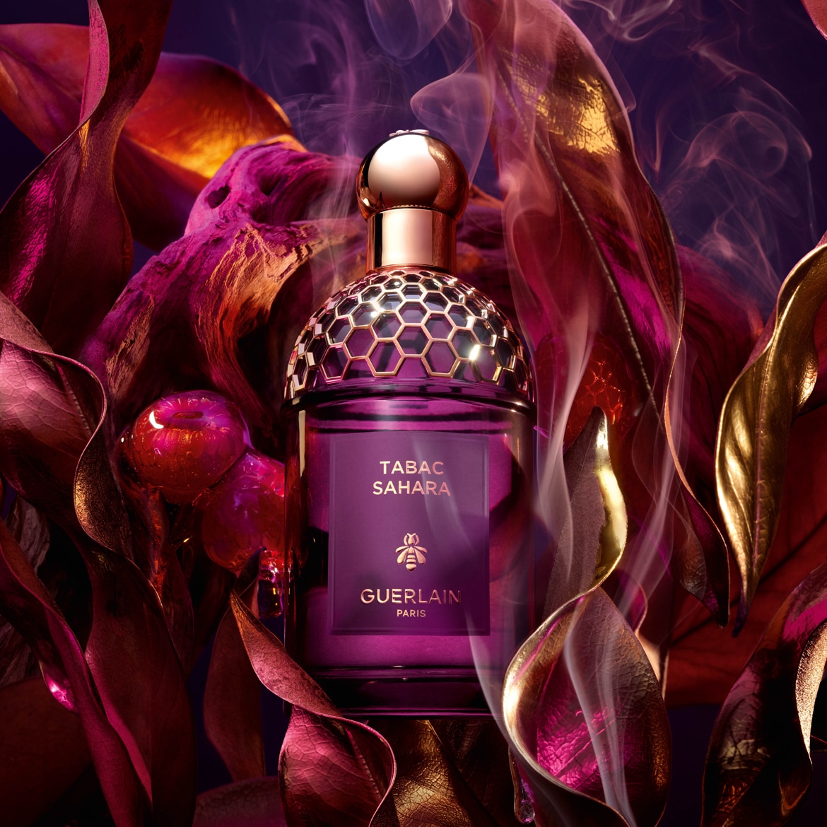 Ecco il profumo Tabac Sahara di Guerlain Paris, presentato in un flacone viola con un tappo dorato a nido d'ape, avvolto da foglie dai toni viola e oro.