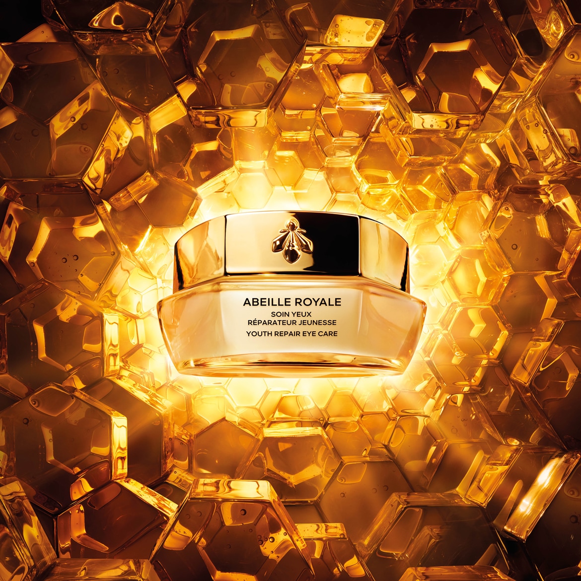 Ecco il trattamento occhi riparatore per la giovinezza Abeille Royale in un barattolo dorato con un'ape, su uno sfondo dorato a nido d'ape.