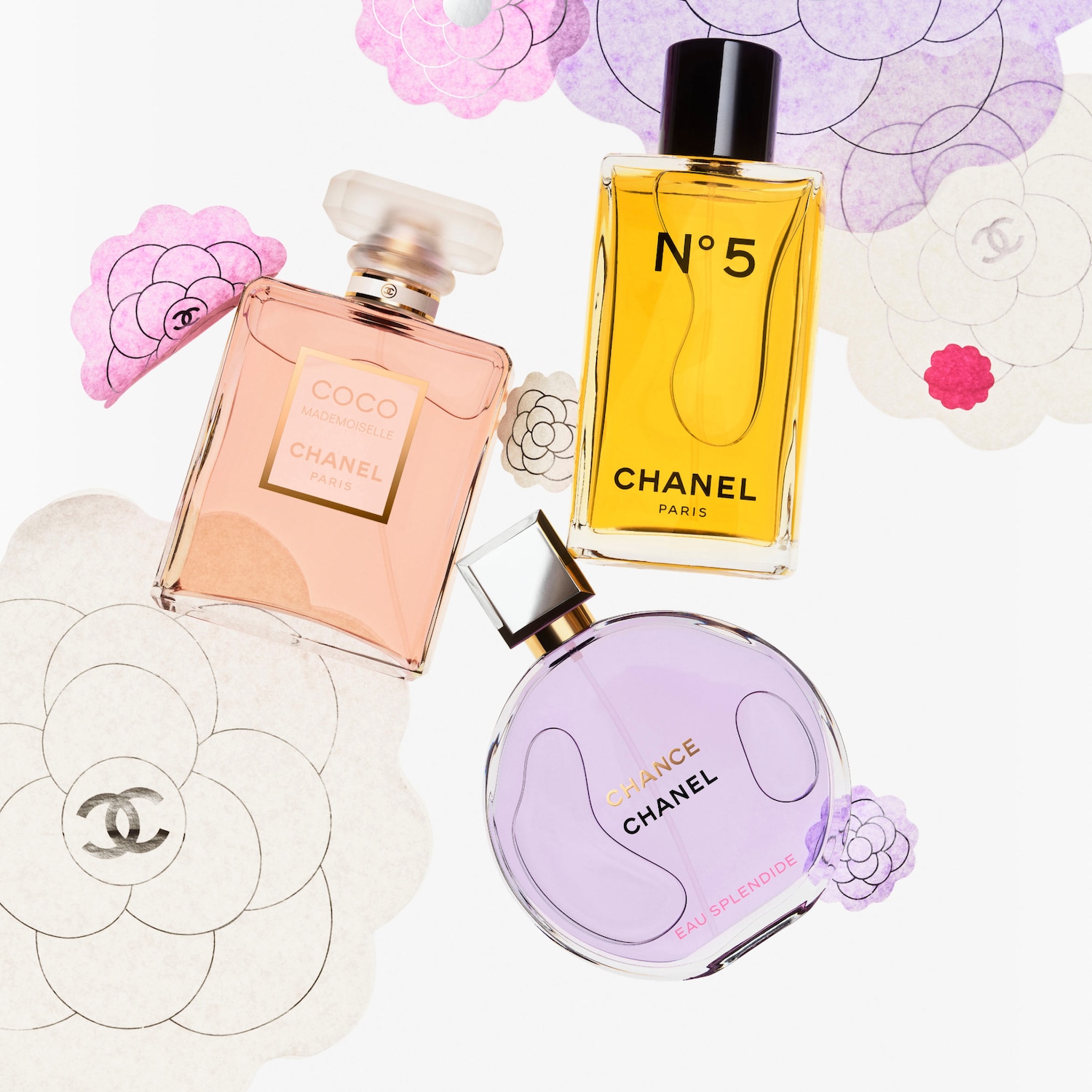 Ecco tre flaconi di profumo Chanel: Coco Mademoiselle in una bottiglia rosa pesca, N°5 in una bottiglia gialla e Chance Eau Splendide in una bottiglia rotonda lilla.