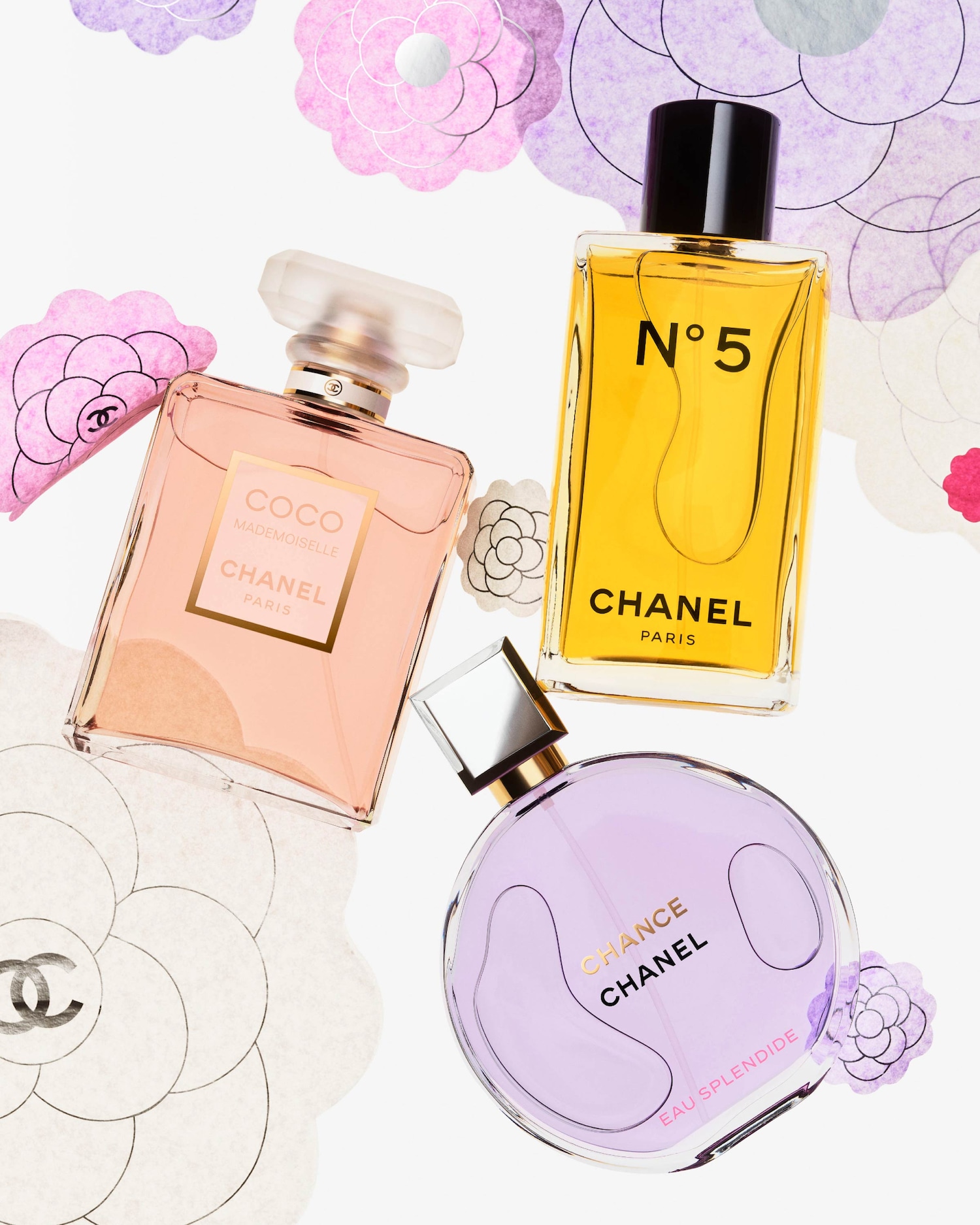 Tre flaconi di profumo Chanel, tra cui Coco Mademoiselle color pesca, N°5 giallo e Chance Eau Splendide lilla, circondati da decorazioni floreali.