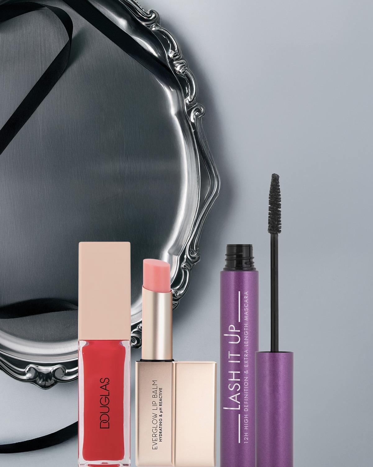 Ecco un set di bellezza con un lucidalabbra rosso Douglas, un balsamo labbra Everglow idratante e un mascara viola Lash It Up per definizione e lunghezza extra.