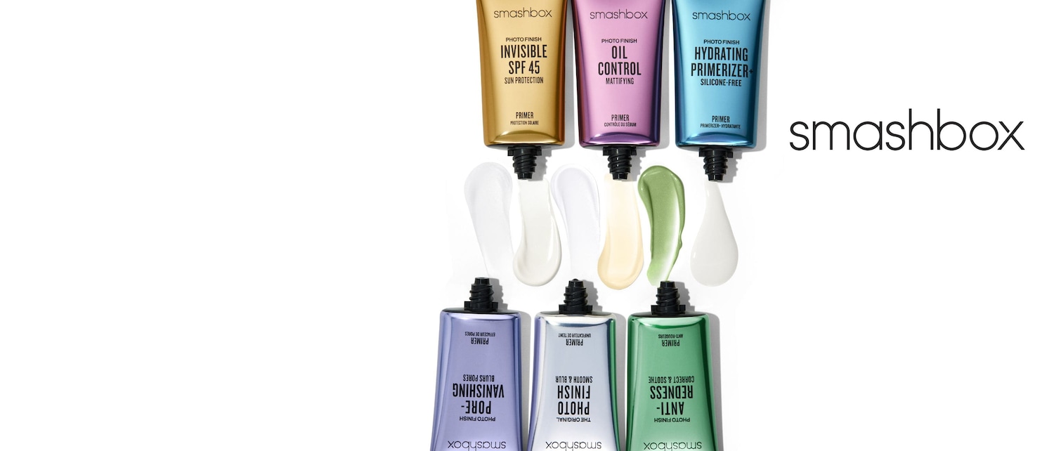 Una gamma di primer Smashbox Photo Finish, tra cui Invisible SPF 45 in confezione dorata, Oil Control in confezione viola e Hydrating Primerizer in confezione blu, con texture cremose.