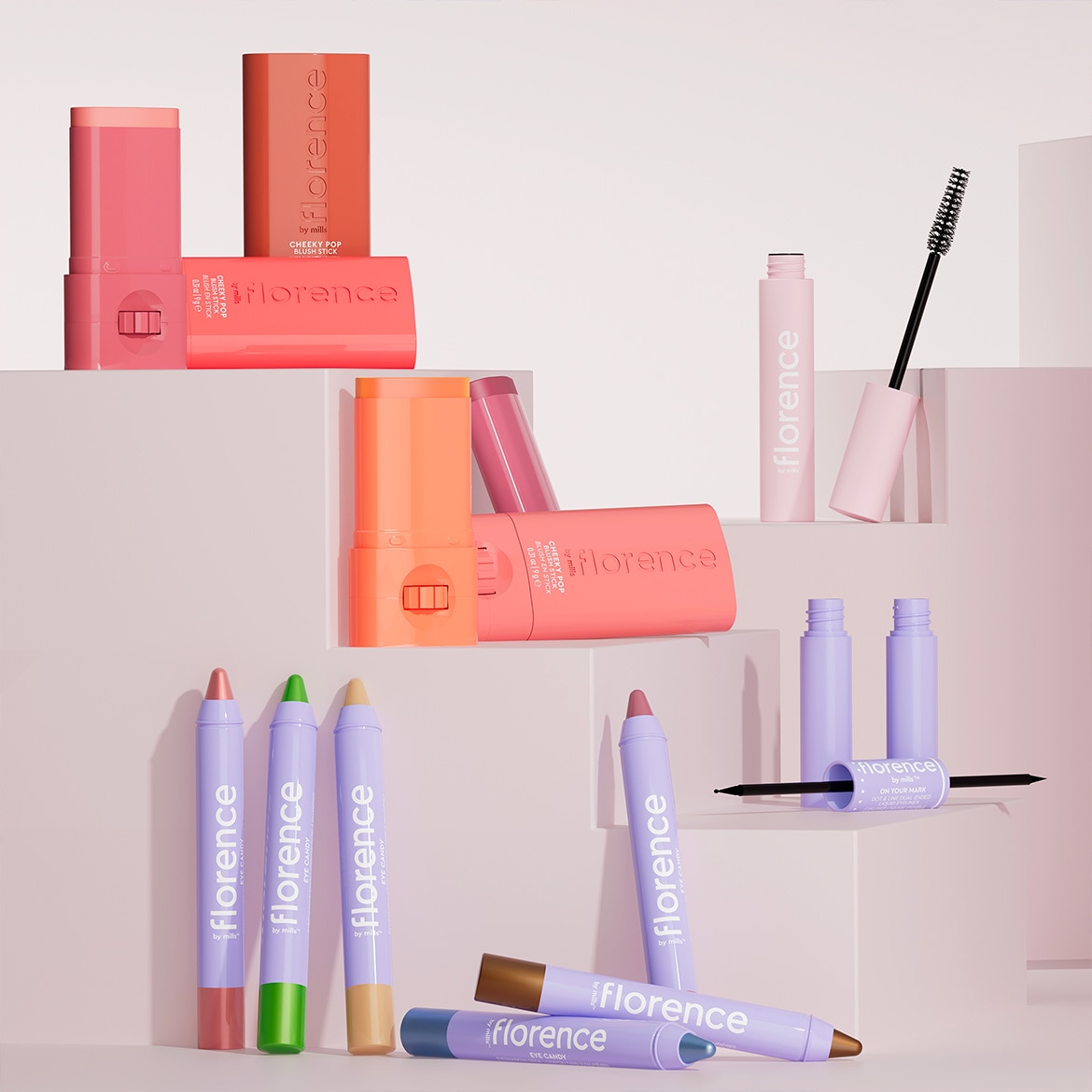 Ecco una gamma di prodotti di bellezza Florence by Mills, tra cui blush in stick color pesca e arancione, mascara rosa con applicatore nero, eyeliner duo viola e pastelli ombretto colorati.