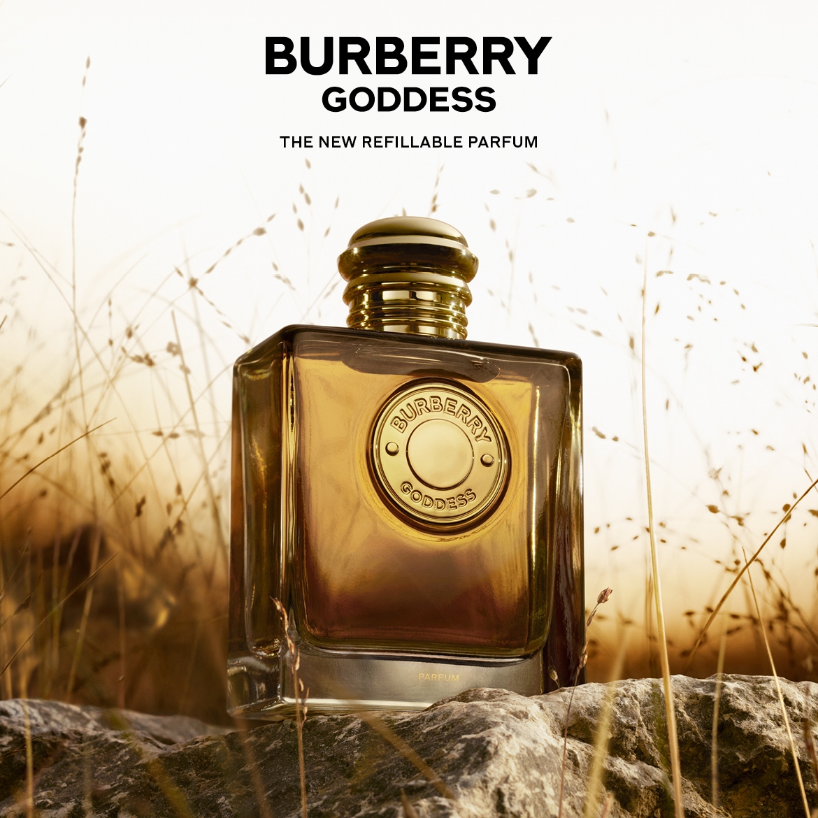 Scopri Burberry Goddess, la nuova fragranza ricaricabile, presentata in un elegante flacone dorato su una base di pietra, immerso in un campo di grano dorato.