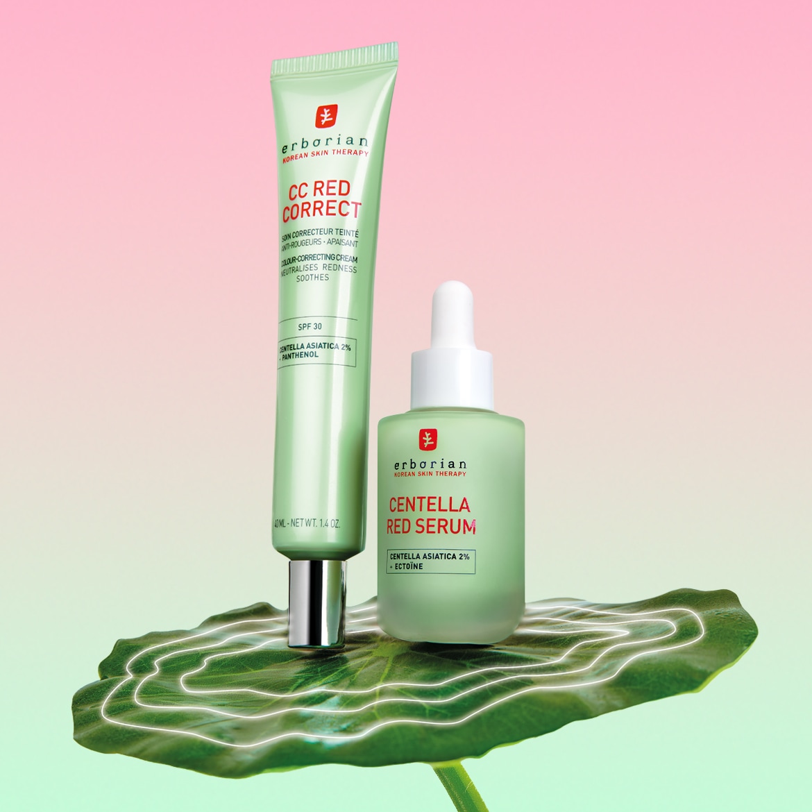 Ecco il CC Red Correct di Erborian, un correttore colorato anti-rossore e lenitivo con SPF 30, insieme al siero rosso Centella, entrambi presentati su una foglia verde.